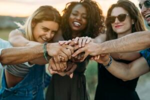 A group of people connecting outdoors at sunset, representing a full and thriving therapy caseload