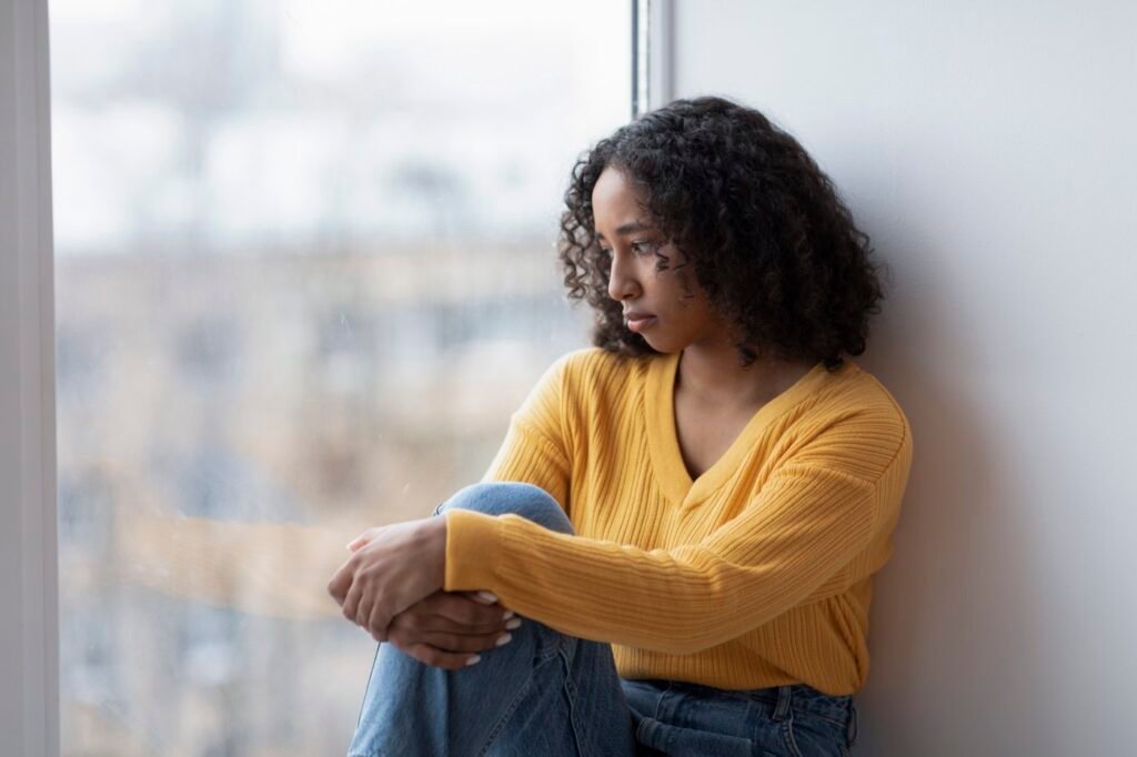 A reflective person sitting by a window, the kind of client a therapy practice hopes to reach