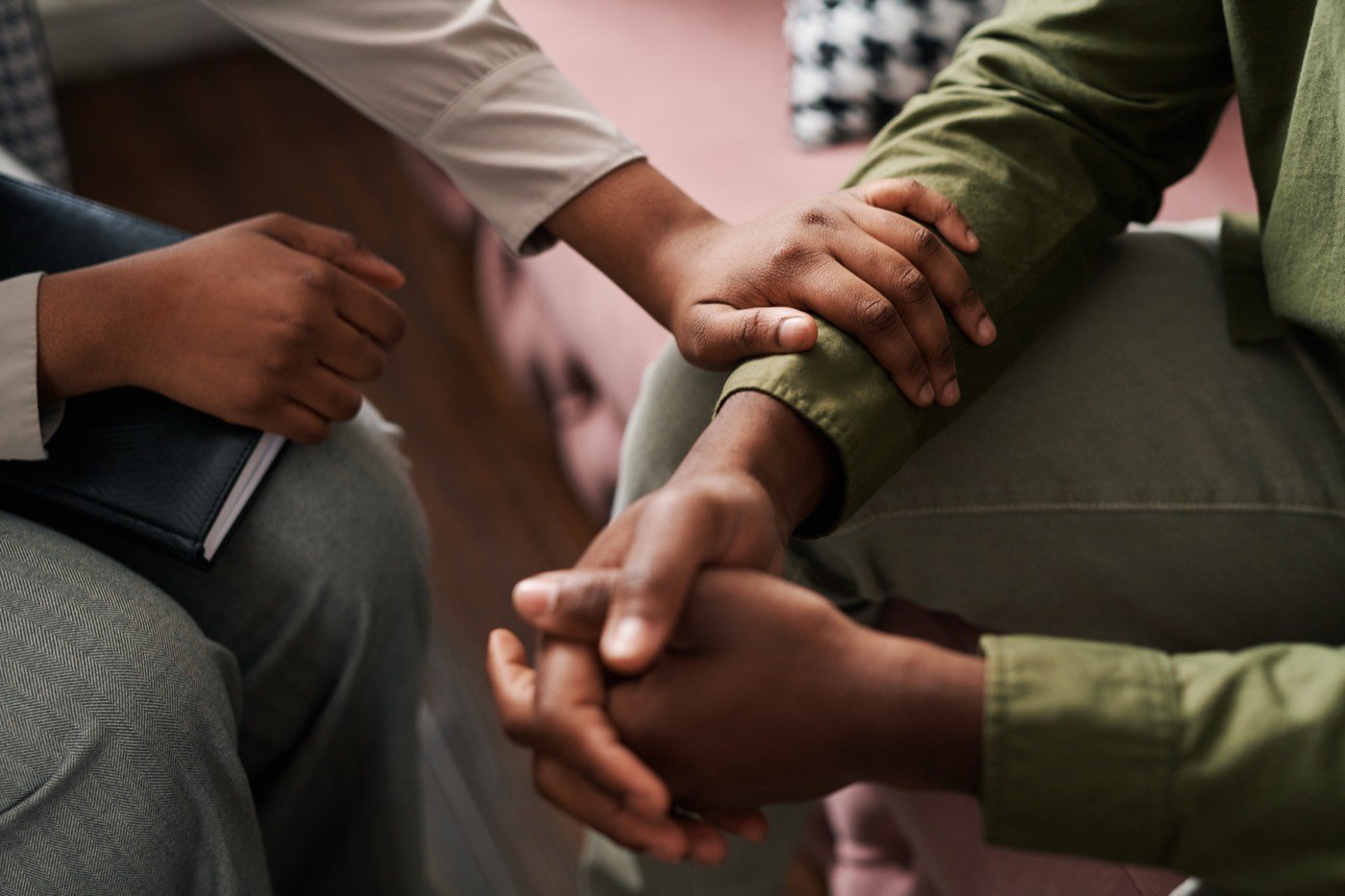 One person offering a supportive hand to another, representing trust in a therapeutic relationship