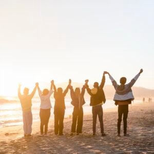 People holding hands on a beach at sunrise, representing trust between a practice and its clients